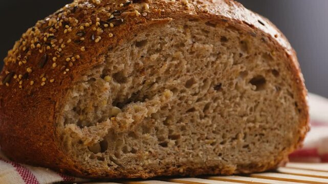 Bread multigrain loaf held in hands, whole wheat seeded crust with millet and seeds, close-up macro shot