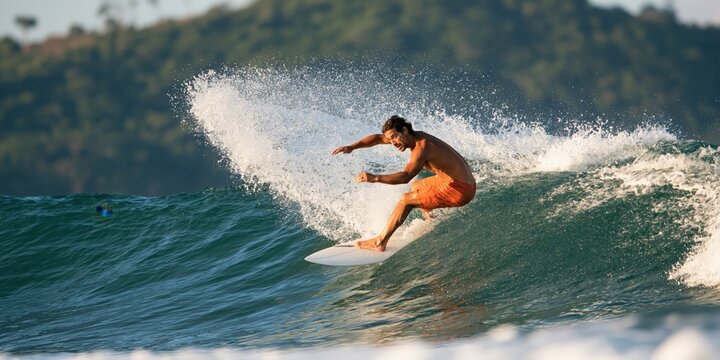Surfer riding ocean wave with spray and green water for sports action banner and beach background