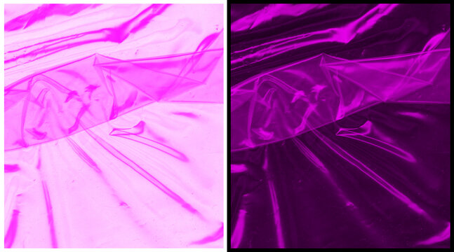 Abstract pink plastic texture background. Creased magenta cellophane wrap surface. Vibrant neon synthetic material with light reflections.
