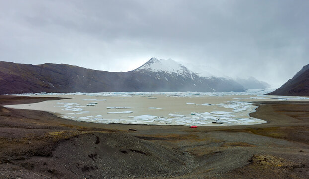 Skalafellsjokull Glacier Heinabergslon, lagoon filled with icebergs under a cloudy sky in a glacial landscape, Iceland