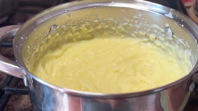 Closeup of creamy mashed potatoes in a steel pot on the stove. Hot homemade puree, cooked potato dish, kitchen cooking, simple comfort meal