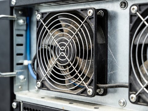 A computer fan is installed and secured inside a computer case, showcasing screws and a metal frame from a close