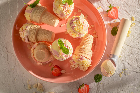 Homemade and juicy strawberry ice cream in a waffle cone.