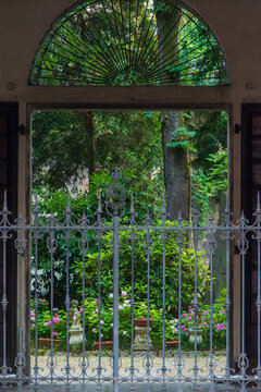 View through ornate gate into lush garden with statues, Italy, Lombardy, Mantua, 3 June 2026