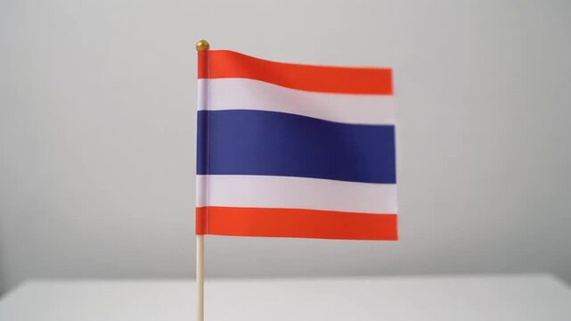 Small Thailand Flag Waving on White Table Desk Stand Isolated on Grey Background