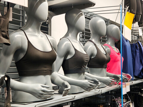 Row of Gray Female Mannequins Wearing Sports Bras in Retail Store