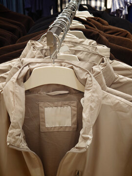 Close-up of Beige Zip-Up Jacket on Hanger in Store