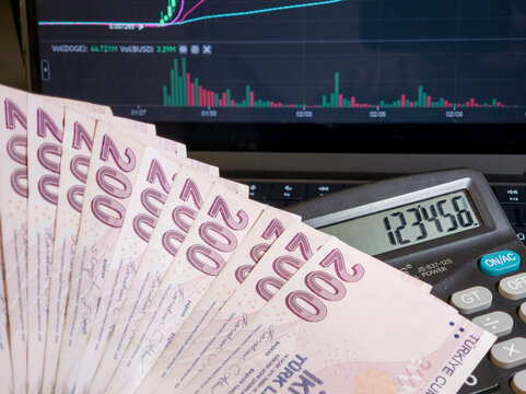 Turkish Lira Banknotes with Calculator and Stock Market Chart on Screen