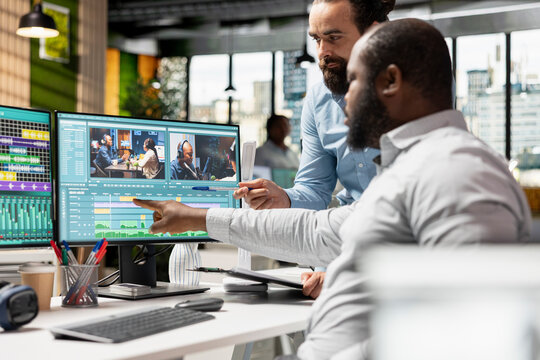 Video editors produce film content on computers in an office, working with timeline transitions, cinematic montage and color grading.