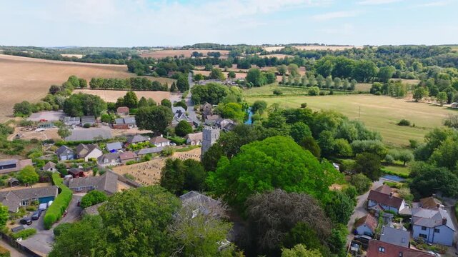 Aerial shot flying over Middle Woodford and River Avon in Wiltshire on a hot summer day. UK