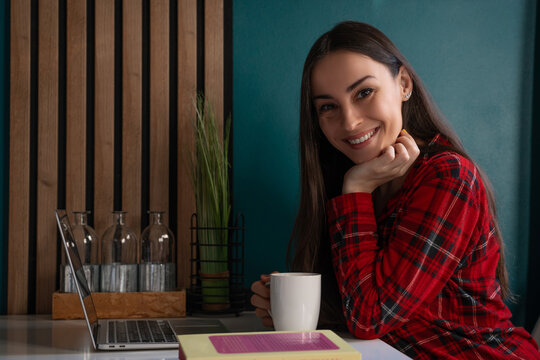 Smiling woman with coffee at home workspace