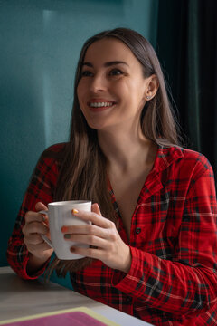 Smiling woman enjoying coffee while relaxing at home