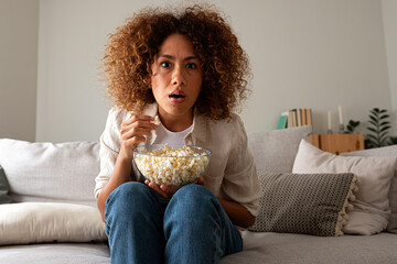 Fototapeta premium Young woman watching horror movie reaction at home