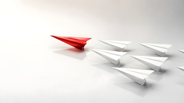 Successful business leadership and strategy metaphor showing a red metallic origami airplane leading white ones on a clean white background.