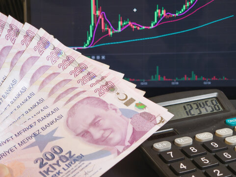 Fan of 200 Turkish Lira Banknotes with Atat&uuml;rk Portrait near Calculator and Stock Screen
