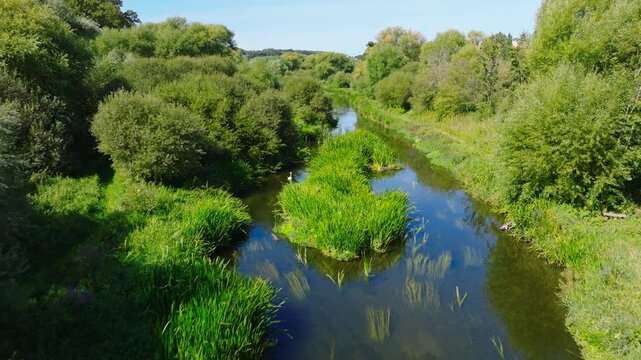Drone shot flying along and downstream the River Avon in the Woodford Valley on a summer day. Wiltshire UK