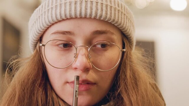 Woman considers moment before drinking straw. Closeup of woman pondering prior to sipping through straw. Detailed shot capturing woman momentarily hesitating before drinking with straw
