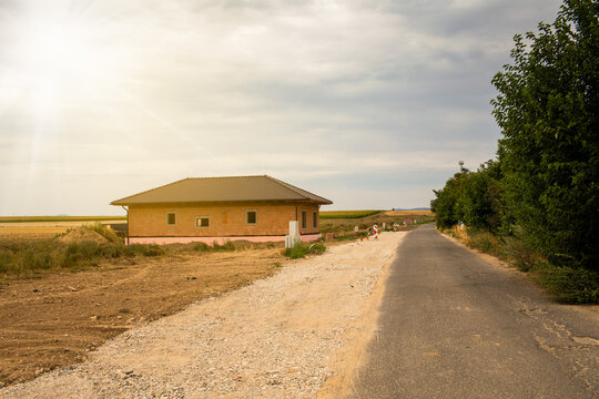 New house construction site with gravel driveway in rural landscape