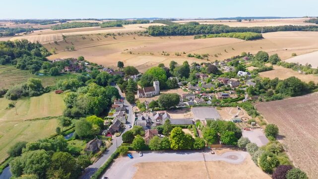 Aerial shot flying over Middle Woodford and River Avon in Wiltshire on a hot summer day. UK