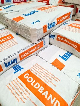 Kiel, Germany - 27. July 2026: Stacking Knauf Goldband gypsum plaster bags for construction
