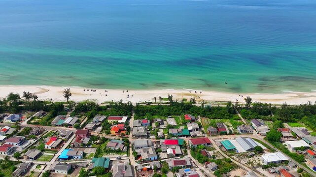 Aerial view of peaceful coastal fishing village with turquoise sea and white sand beach in Quang Tri Vietnam