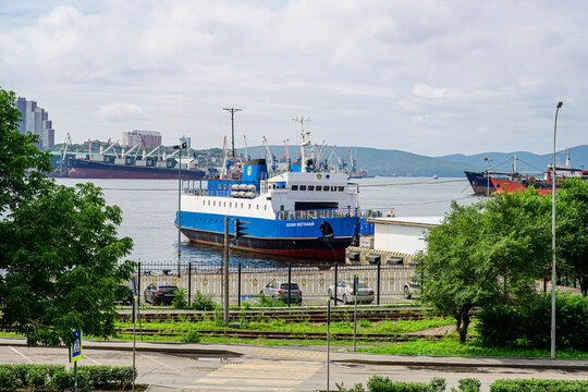 Vladivostok, Russia - July 28, 2026: Seascape with the moored Bosfor Vostochny ferry and vessels in the Golden Horn bay with port cranes in distance.