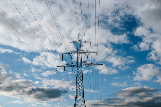 Power Lines Against Cloudy Sky.Electric transmission pylon and overhead power lines.electricity distribution, power infrastructure,energy security,utility network,sustainable energy transition 
