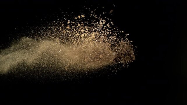 Super Slow Motion Shot Flying Soil Isolated on Black at 1000fps.