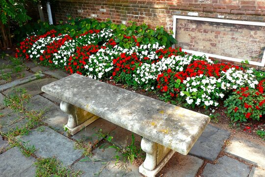 Stone bench and red and white flowergarden