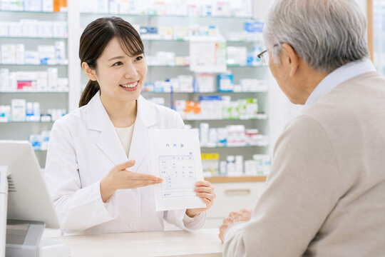 高齢患者に薬を説明する女性薬剤師