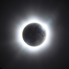 Naklejka premium Solar eclipse with glowing corona ring around dark moon in black sky