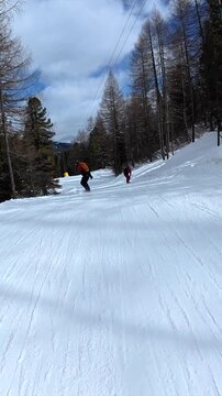 Friends snowboarding together down a snowy mountain slope