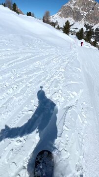 First person view of snowboarding on a sunny day in the dolomites