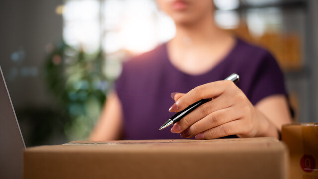 Small business owner prepares shipping package for e-commerce fulfillment, online orders, parcel delivery, inventory management, logistics operations, product packaging, and customer shipping.