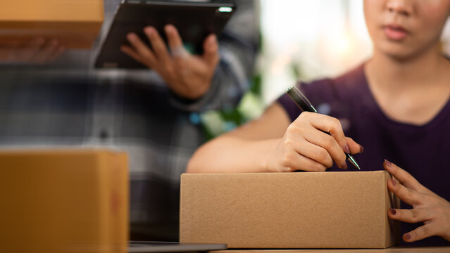 Warehouse employee prepares shipping packages for order fulfillment, e-commerce logistics, inventory management, parcel delivery, warehouse operations, supply chain, and distribution services.