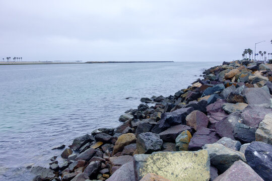 Coastal view of Mission Bay Entrance Channel in San Diego featuring a prominent rocky riprap jetty and calm water, California