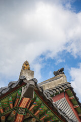 Monkey japsang ornament above dancheong-painted eaves of a traditional korean building in south korea. © 완수 안