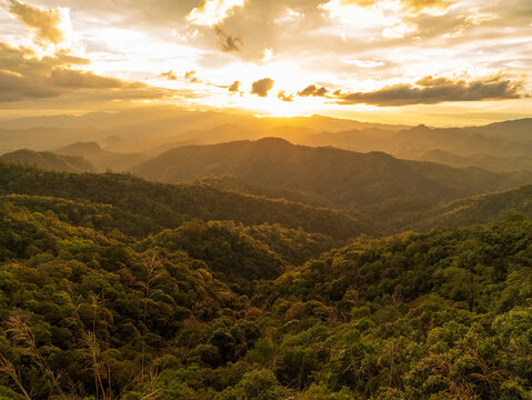 Dramatic sunset over mountain landscape. Dawn sky gold dusk time cloudscape with sunlight. Blue golden sky sunrise dramatic beautiful landscape mountain. Beautiful landscape foggy hills twilight time
