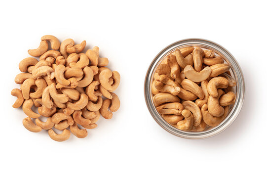 Top- view of crunchy roasted cashew nuts, featuring both neat pile and a glass jar filled with premium nuts, isolated on white background. Perfect for healthy snack and food packaging.