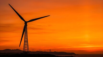 Obraz premium Wind turbine silhouette standing against a vibrant orange sunset sky