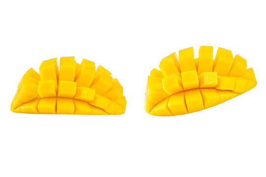 Two fresh, ripe mango halves are diced isolated on white background.