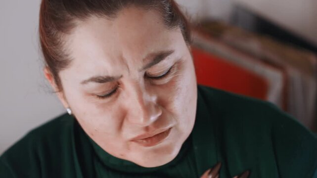 Lady showing signs of pain. Middleaged woman demonstrating symptoms of distress at her residence. Woman in her middle years showing clear indications of pain within her private home