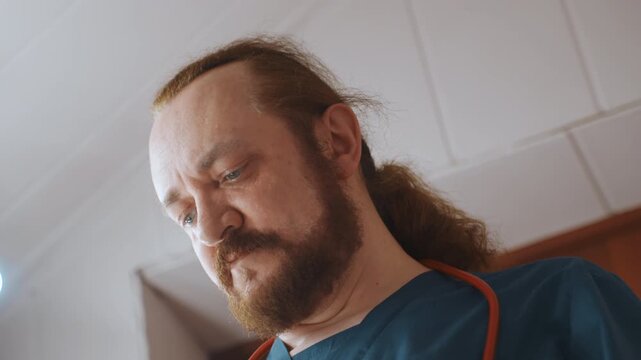Paramedic at home putting on mask, stethoscope over shoulders, serious focused expression, wooden door and ceiling lights in background, preparing for urgent response while following safety protocol