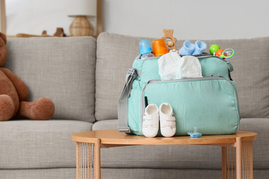 Baby bag with accessories and booties on table in living room