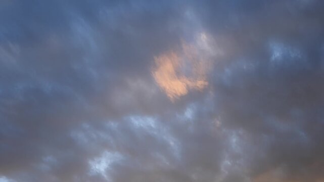 Timelapse of late day sunset blue and pink clouds moving across the sky fill the frame
