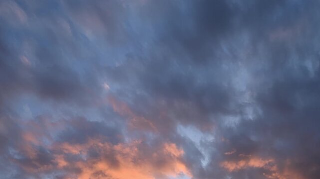 Timelapse of bright pink and purple clouds drifting through a late day summer sky
