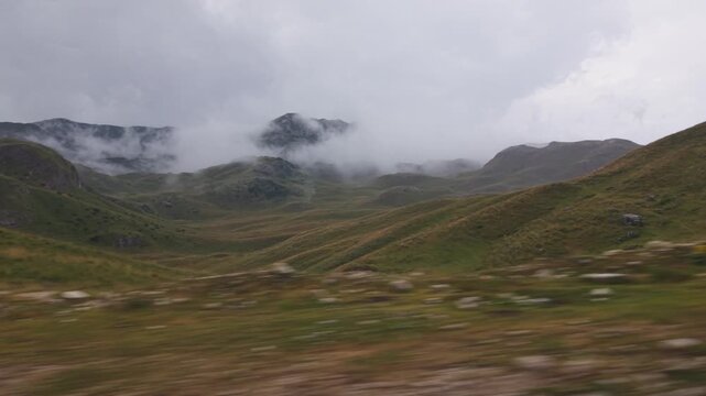 Scenic view of misty rolling green hills and fog-covered mountains in Durmitor National Park, Montenegro