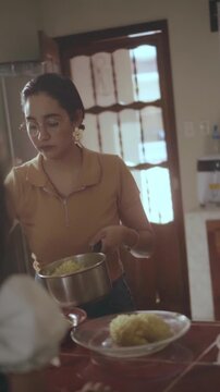Mother preparing and serving dinner for family