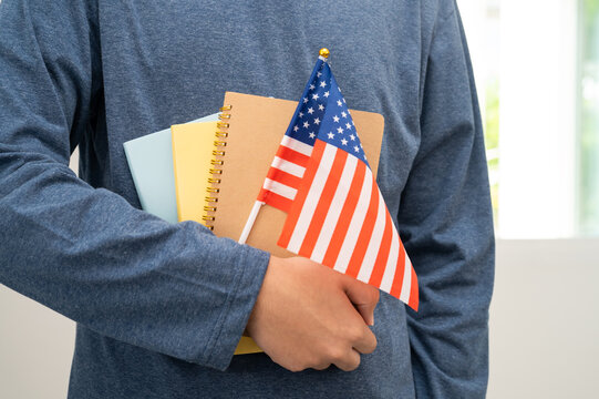 Learn English language, Asian teenage student hold book with flag in course at school.