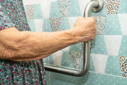 Asian elderly woman patient use toilet bathroom handle security in nursing hospital, healthy strong medical.